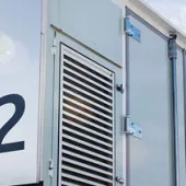 Close-up of Advancion Energy Storage units with the number 312 on a sunny day with clouds in the sky.