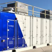 A large industrial container with a blue and white design, labeled 'Fluence' and '111', under a clear blue sky.