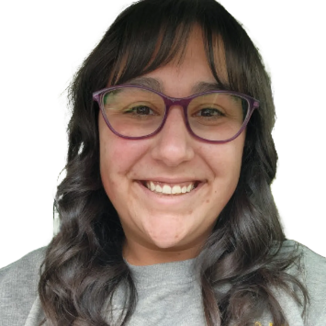 Jen Burfield deadshot. Smiling person with long dark hair and purple glasses, wearing a grey shirt.