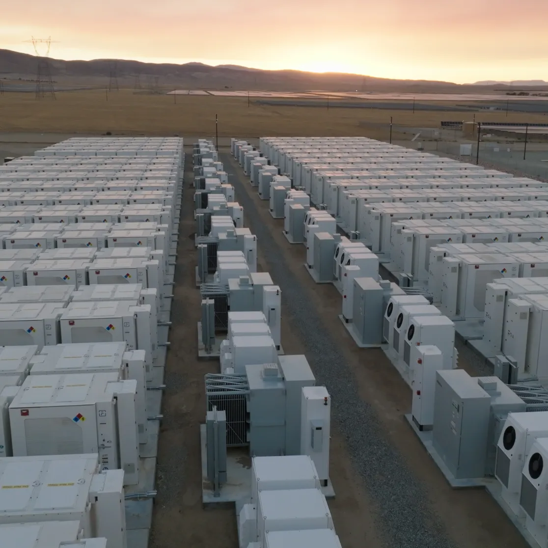 Aerial view of AES battery energy storage containers at a California facility during sunset, with open landscape in the background.
