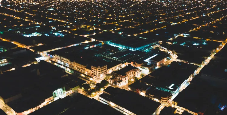 Aerial view of a brightly lit city grid at night, showcasing urban lights, infrastructure, and energy distribution across a sprawling metropolitan landscape.